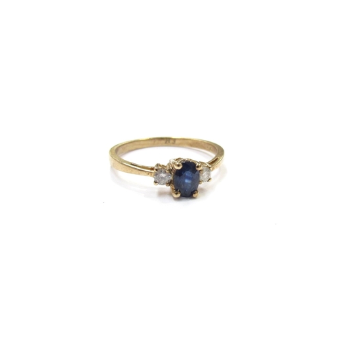 9352 - A sapphire and diamond ring, the oval sapphire flanked by diamonds, stamped 9ct. Size P, 1.8g