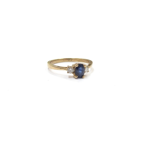 9352 - A sapphire and diamond ring, the oval sapphire flanked by diamonds, stamped 9ct. Size P, 1.8g