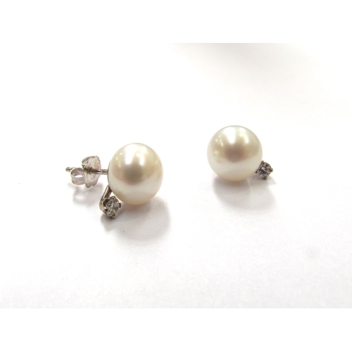 9361 - A pair of single pearl and diamond earrings, stamped 14k to backs, 2.1g         (C)