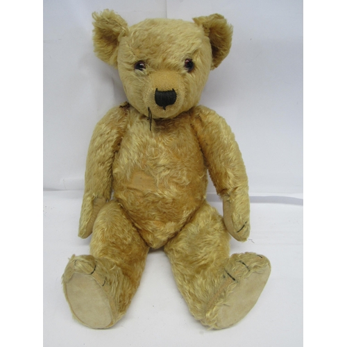 7114 - A mid 20th Century careworn straw filled golden mohair teddy bear with amber and black plastic eyes,... 