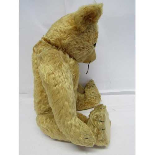 7114 - A mid 20th Century careworn straw filled golden mohair teddy bear with amber and black plastic eyes,... 