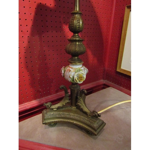 1078 - A brass table lamp on turned and ceramic column with applied flowers on tri-form and footed base, pi... 