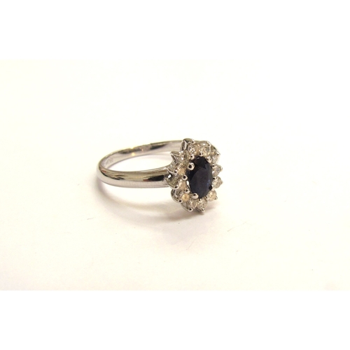 9058 - An 18ct white gold sapphire and diamond cluster ring. Size P, 2.9g