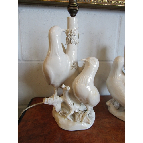 A pair of blanc-de-chine table lamps decorated with doves gathered ...