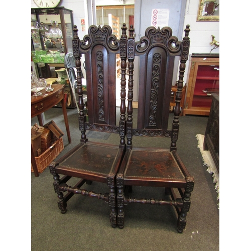 1098 - A pair of 17th Century style carved oak hall chairs with coronet crest, painted seal and stud border... 