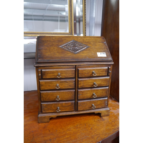 2190 - An oak decanter and glass case in the design of a small bureau