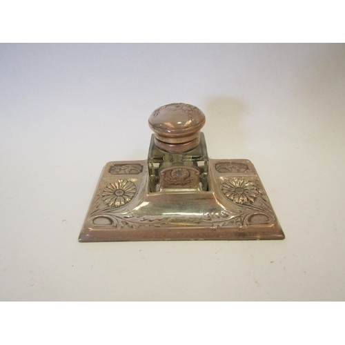 1278 - A Continental white metal and glass inkwell and stand with embossed floral decoration (marks rubbed)... 