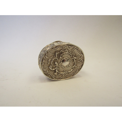 1323 - A Continental silver oval pot with embossed floral decoration.  Import marks London 1894