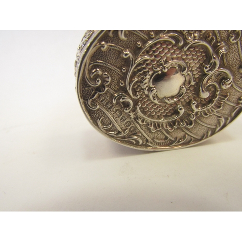 1323 - A Continental silver oval pot with embossed floral decoration.  Import marks London 1894