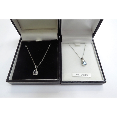 9409 - A 9ct white gold chain hung with a 9ct gold topaz pendant, 44cm long and a diamond and tanzanite pen... 