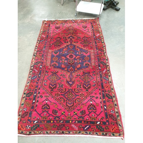 2325 - A handwoven Persian pink red and blue carpet. 133cmx 247cm   (R) £200