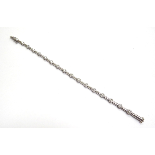 9009 - An 18ct white gold bracelet set with seventeen diamonds in rubover settings, 19cm long, 13.3g