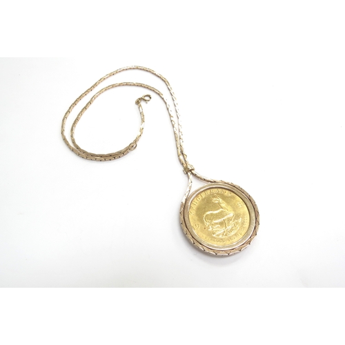 9068 - A 1981 1oz gold Kruggerand in loose 9ct gold pendant mount hung on 9ct gold chain, 54.5g total