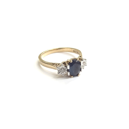 9192 - A 9ct gold sapphire and diamond ring, the central oval sapphire flanked by diamonds. Size M, 2.7g