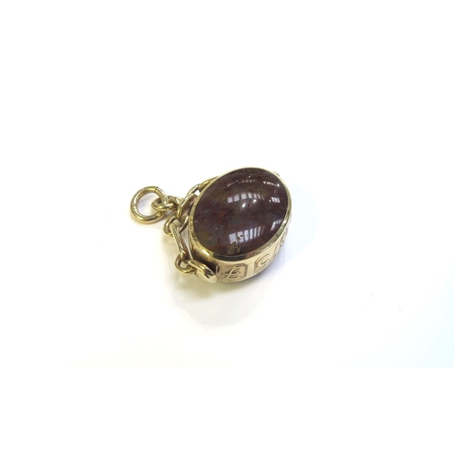 9193 - A 9ct gold mounted swivel fob with polished multi-coloured stone, 9.7g