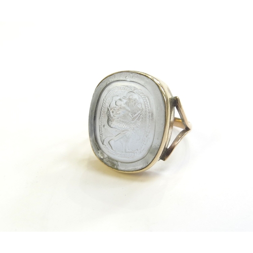 9316 - A gold intaglio ring of a seated man with sword, stamped 9ct, 20mm x 17mm. Size S, 6g