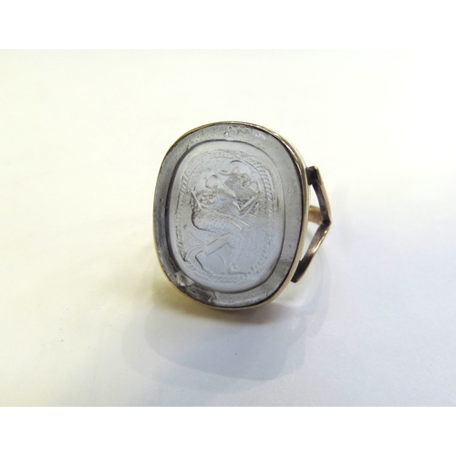 9316 - A gold intaglio ring of a seated man with sword, stamped 9ct, 20mm x 17mm. Size S, 6g