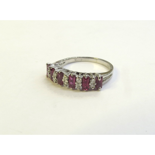 9174 - An 18ct white gold ruby and diamond half hoop ring. Size O, 3.2g