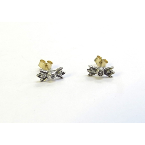 9217 - A pair of stud earrings set with three old cut diamonds as bows, 1.2g