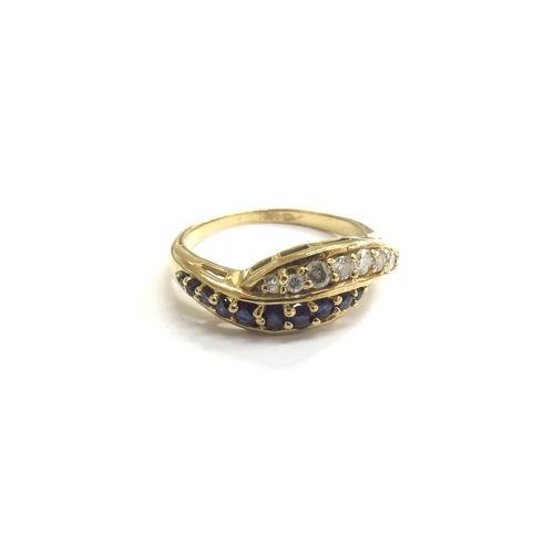 9215 - An 18ct gold sapphire and diamond line crossover ring. Size O, 3.8g   (C)