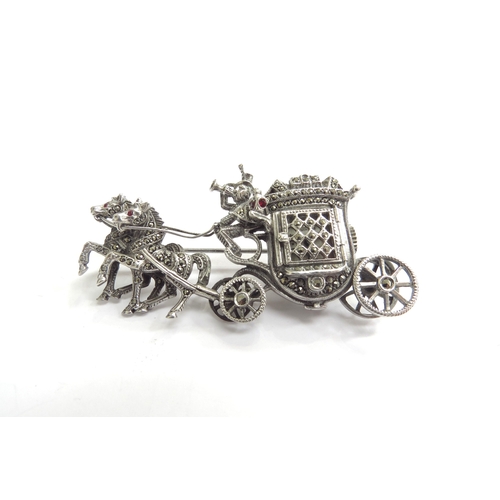 9226 - A marcasite set brooch as a coach and horses, driver with bugle, the coach door opening to reveal a ... 