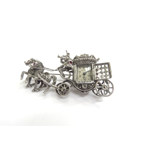 9226 - A marcasite set brooch as a coach and horses, driver with bugle, the coach door opening to reveal a ... 