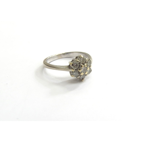 9205 - An 18ct white gold diamond daisy ring. Size J, 2.9g   (C)