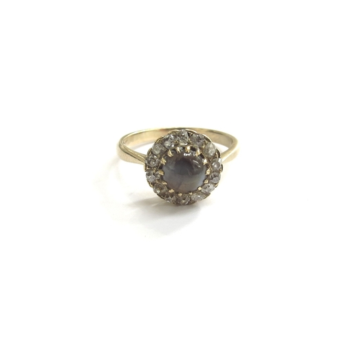 9271 - A gold ring centrally set with a round cats eye cabochon framed by diamonds, unmarked. Size L, 2.4g