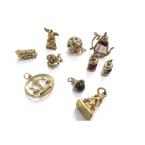 9240 - A quantity of 9ct gold charms including, Bunny, train, signal lamps, smokey quartz kettle with 9ct g... 