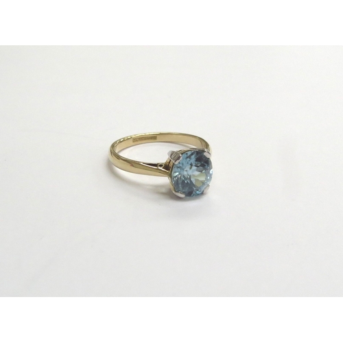 9207 - An 18ct gold platinum set blue zircon solitaire ring. Size M, 3.1g   (C)