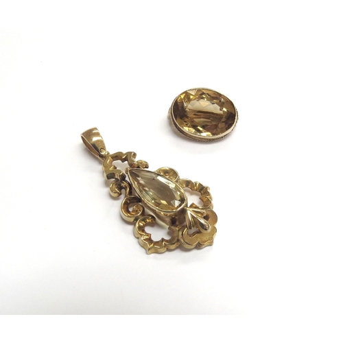 9301 - An oval citrine brooch and a citrine set ornate pendant in scroll mount, 4.5cm long, unmarked, 9.8g ... 