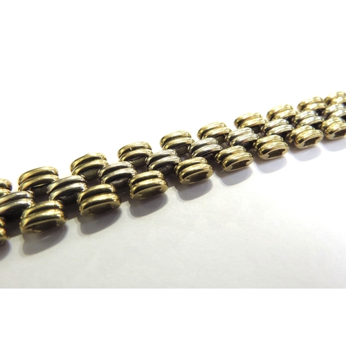 9067 - An 18ct two tone gold brick link flexible bracelet, 20cm long, 35.6g