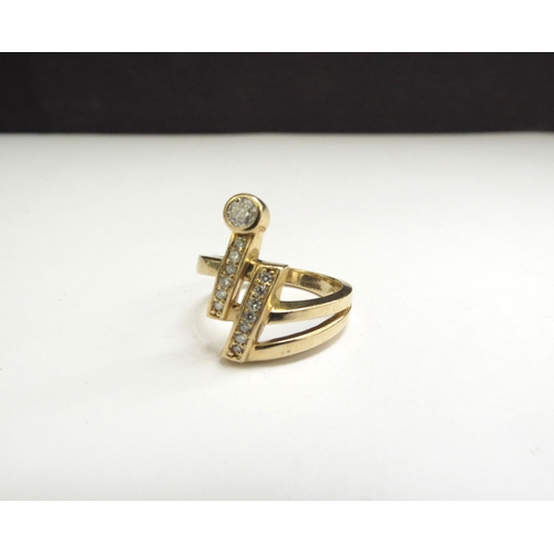 9142 - A gold ring with two lines of vertical diamonds one terminating with a round cut diamond, stamped 14... 