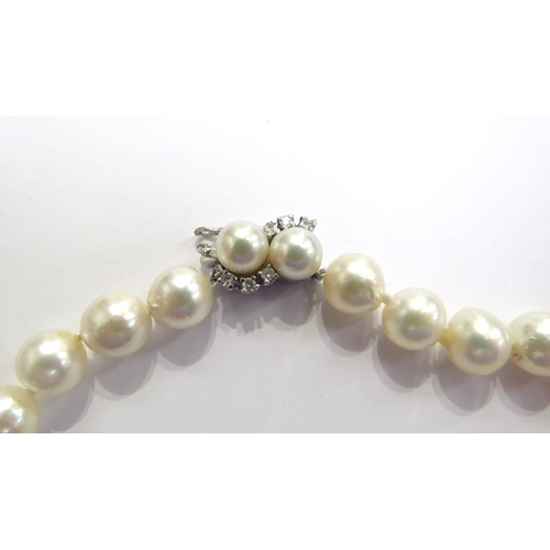 9340 - A single strand of irregular shaped pearls with a white gold pearl and diamond set clasp stamped 14k... 