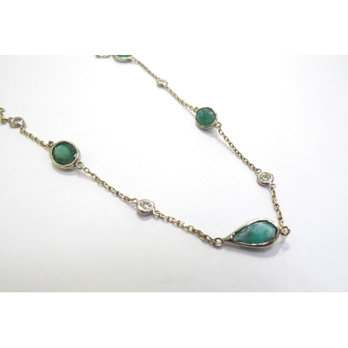 9425 - An emerald and diamond necklace with equally spaced stones on trace link chain, four oval emeralds a... 