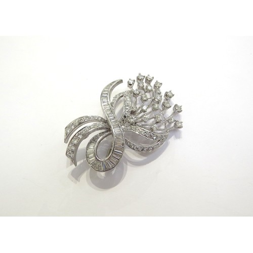 9276 - A diamond encrusted brooch as a floral spray of round brilliant cut diamonds with a baguette cut dia... 