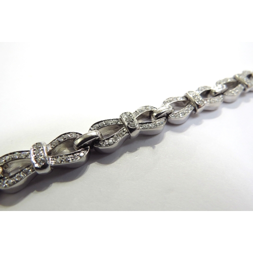 9442 - A Tiffany and Co white gold and diamond bracelet, brilliant cut diamonds set in bow style links, 4.2... 