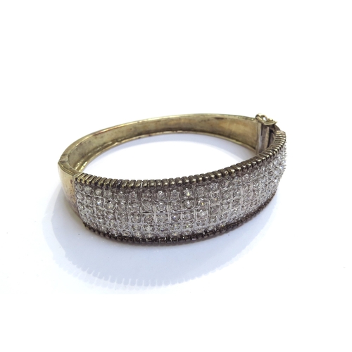 9468 - A 9ct gold hinged bangle set with clear stones, 40g