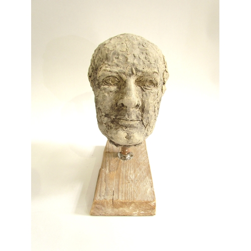 7553 - A ceramic hand worked studio sculpture of a mans head, set on a wooden plinth base. 31cm high