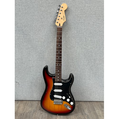 5134 - A Fender Squier Stratocaster electric guitar, sunburst body with white guard and Indian rosewood fin... 