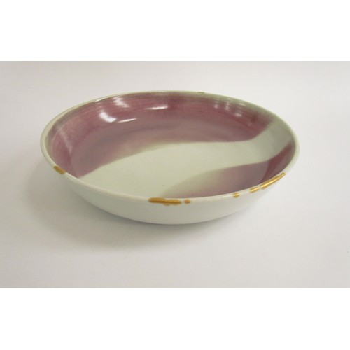 7114 - SHEILA CASSON (b.1930): A studio pottery shallow bowl with blush interior with wipe gold to rim, 25c... 