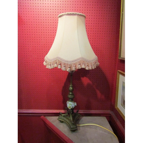 1021 - A brass table lamp on turned and ceramic column with applied flowers on tri-form and footed base, pi... 