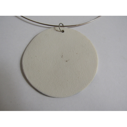 7258 - A porcelain plaque pendant on a white metal torc, hand painted with bird and wave detail. 7cm diamet... 