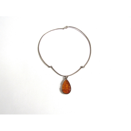 7256 - A silver torc necklace with an amber teardrop pendant