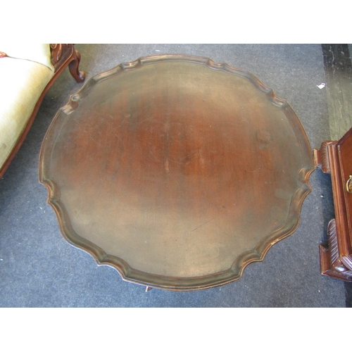 1100 - A stained mahogany occasional table with piecrust top, wrythen column, tripod legs on ball and claw ... 