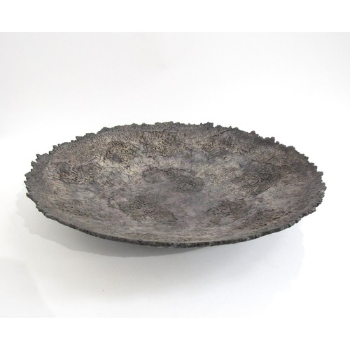 7117 - BARRY GUPPY (1937-2013) A large studio pottery charger with textured detail. Impressed seal and date... 