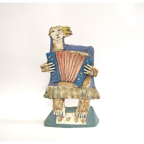 7057 - CHRISTY KEENEY (b.1958): A studio pottery figure of an accordian player, signed verso, 41.5cm high (... 