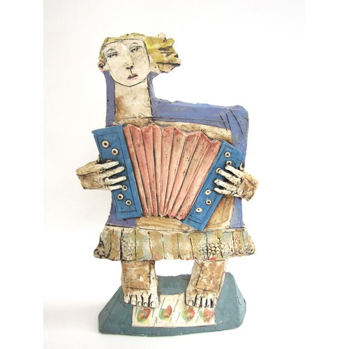 7057 - CHRISTY KEENEY (b.1958): A studio pottery figure of an accordian player, signed verso, 41.5cm high (... 