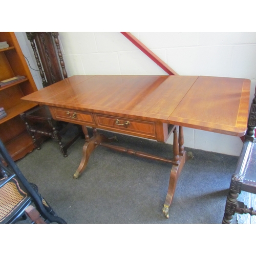 1008 - A reproduction mahogany sofa table, twin frieze drawers, reeded supports, brass lion paw feet