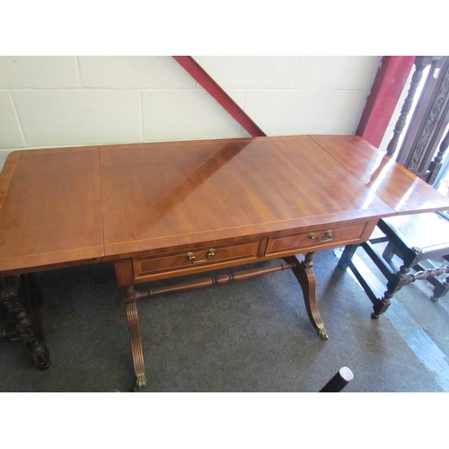 1008 - A reproduction mahogany sofa table, twin frieze drawers, reeded supports, brass lion paw feet